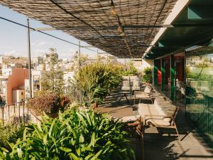 a balcony of a building with chairs and plants at Casa Camper Barcelona in Barcelona
