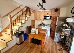 a kitchen with a staircase and a table in a room at Gîte de la vallee in Coaticook