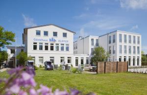 a building with chairs in the grass in front of it at Haus KLIPPER Norderney in Norderney