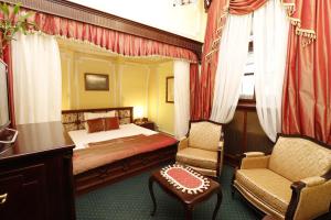 a bedroom with a bed and a chair and a table at Garni Hotel Leopold I in Novi Sad +59 photos