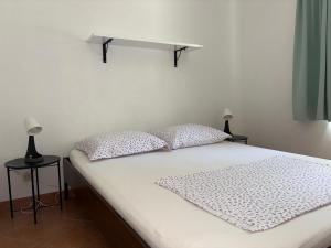 a white bed with two pillows on top of it at Robinson Marko in Gdinj