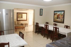 a dining room with two tables and a refrigerator at Oria Lodge in Cape Town