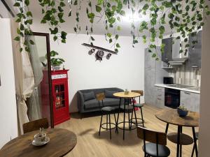 a living room with two tables and a red phone booth at Markylian House in Castiglione del Lago