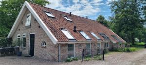 a brick house with a roof with windows on it at 't Achterhuis in Alteveer +16 photos