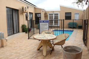 a patio with a table and two chairs next to a pool at Oria Lodge in Cape Town