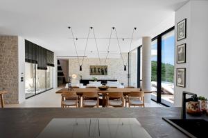 a dining room and living room with a table and chairs at Villa Orama Corfu in Karyótikon