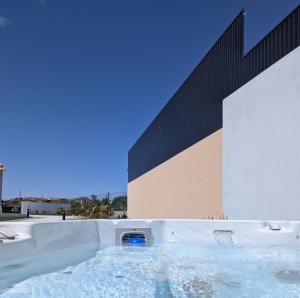 a hot tub in front of a building at Casinhas do Penedo in Canelas