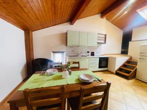 a kitchen with a wooden table with chairs and a dining room at Chiasso Swiss Apartment by RentuGoo Travel in Chiasso