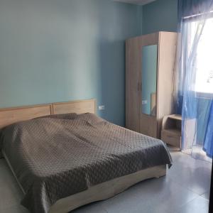 a bedroom with a bed and a mirror and a window at Giomari in Shekhvetili