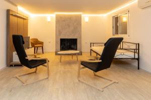 a room with two chairs and a bed and a fireplace at Nataly's Gardens with Pool Lagonissi in Lagonissi