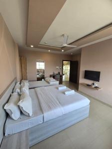 a large bedroom with two beds and a flat screen tv at SILVER REGENCY in Guwahati +5 photos