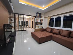 a living room with a brown couch in a room at Minie House Hatyai in Hat Yai