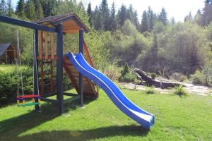 un parque infantil con un tobogán azul en el césped en Rekreačný dom Habovka, en Habovka