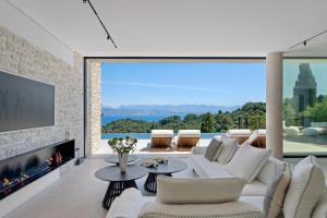 a living room with a white couch and a fireplace at Villa Orama Corfu in Karyótikon