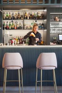 a woman standing behind a bar with a piece of food at Hotel Torino Wellness & Spa in Diano Marina