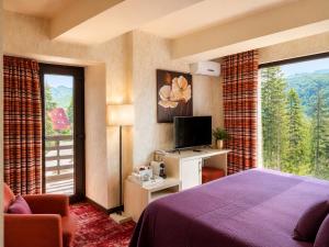 a hotel room with a bed and a large window at Ioana Boutique Hotel in Sinaia
