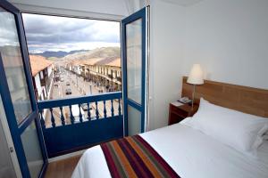 a bedroom with a bed and a view of a city at Hotel Plaza de Armas Cusco in Cusco