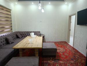 a living room with a couch and a wooden table at COMFORT house in Khiva