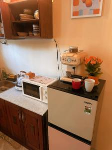 a kitchen with a microwave on top of a refrigerator at The Mê Linh House in Nha Trang