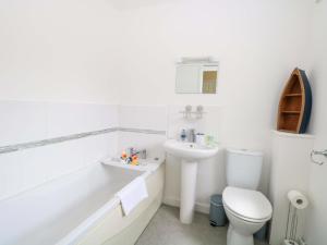 a white bathroom with a toilet and a sink at The Mill House Gardens in Lowestoft +31 photos