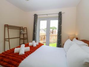 a bedroom with a large white bed with a window at The Mill House Gardens in Lowestoft