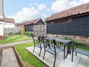 a patio with a table and chairs in a yard at The Mill House Gardens in Lowestoft