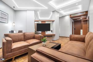 a living room with two couches and a tv at Northern Residency in Srinagar
