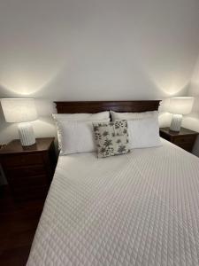 a bedroom with a bed with two lamps on it at Praia - Mar in Ovar