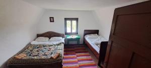 a small room with two beds and a table at Domacinstvo Obradovic Nadgora in Nadgora