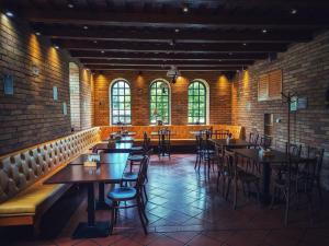 a dining room with tables and chairs and windows at Hotel Cabernet in Villánykövesd +42 photos