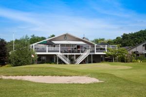 een huis op een golfbaan met een groen bij Hotel Beemster in Middenbeemster