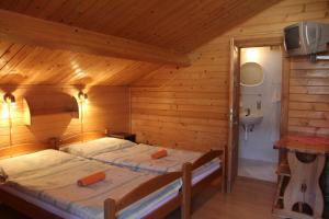 Un dormitorio con dos camas en una cabaña de madera. en Rekreačný dom Habovka, en Habovka