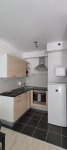 a kitchen with white appliances and a black floor at Corvin Center Suites in Budapest