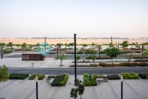 a view of a park with benches and a street at Bloomfields Studio in Oasis Masdar in Abu Dhabi