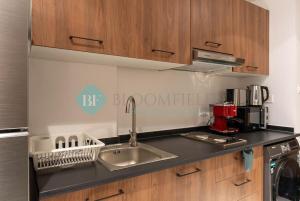 a kitchen with a sink and a counter top at Bloomfields Studio in Oasis Masdar in Abu Dhabi +5 photos