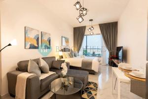 a living room with a couch and a bed at Bloomfields Studio in Oasis Masdar in Abu Dhabi