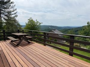 a wooden deck with a picnic table on a fence at Baron in Beffe