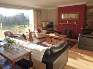 a living room with a couch and a table at Camusmore House in Aviemore