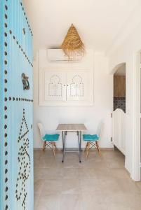 a dining room with a table and two chairs at Dar Ahlem Djerba in El Guecheïne
