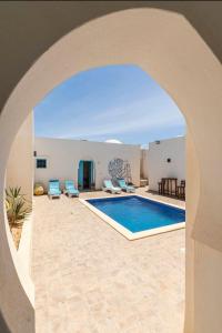 an archway leading to a swimming pool in a villa at Dar Ahlem Djerba in El Guecheïne