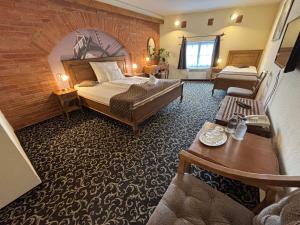 a hotel room with a bed and a table at Malom Hotel in Debrecen