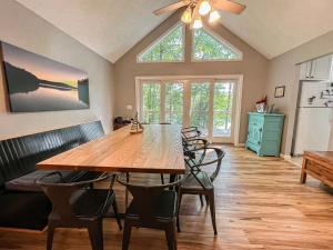 a dining room with a wooden table and chairs at Lakefront Dock Fire Pit Hot Tub Value in Swanton