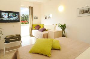 a bedroom with two beds and a flat screen tv at Dolce Vita Suite Alghero in Alghero