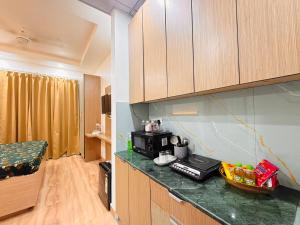 a kitchen with a counter top with a microwave at The Amberwood Escape in Greater Noida