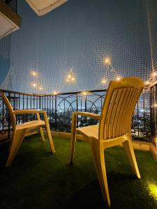 two chairs on a balcony with a view of a city at The Amberwood Escape in Greater Noida