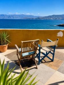 two chairs sitting on a patio overlooking the ocean at Horn Agios Nikolaos in Agios Nikolaos +18 photos