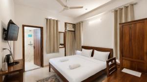 a bedroom with a white bed and a television at Cozy Den in Jaipur +42 photos