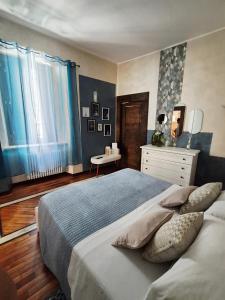 a bedroom with a large bed and a dresser at Dietro al Corso in LʼAquila