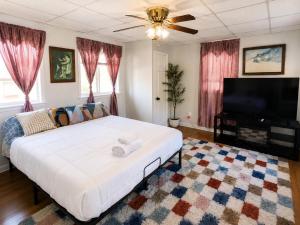a bedroom with a large bed and a flat screen tv at Fall River Stay Urban Haven Entire Suites Cozy 4BR in Fall River