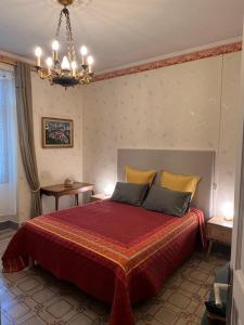 a bedroom with a bed and a chandelier at Le Mas Ferrand in Graveson